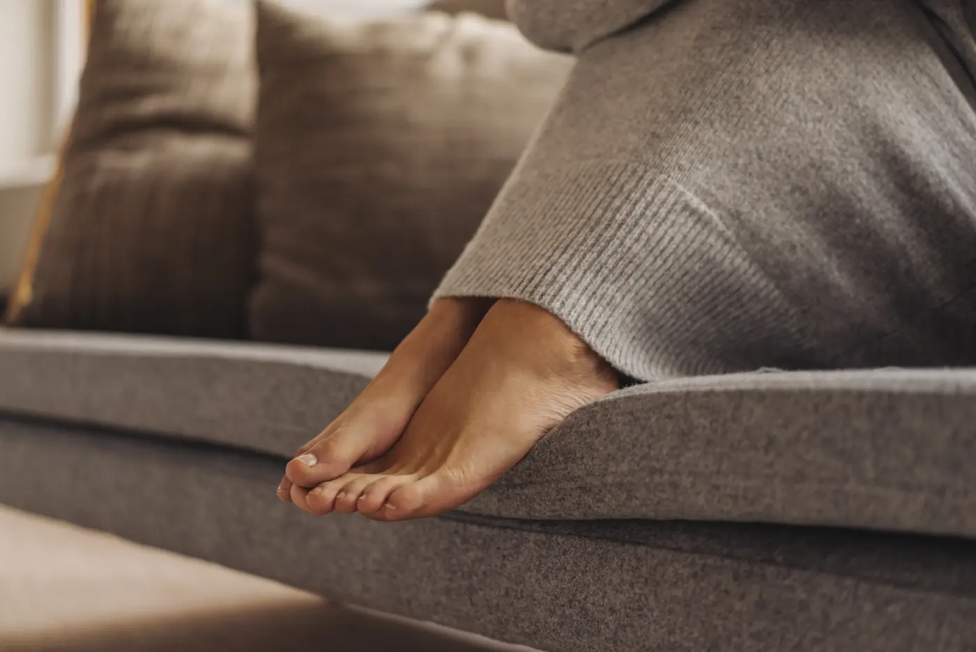 Füße einer Frau auf dem Sofa