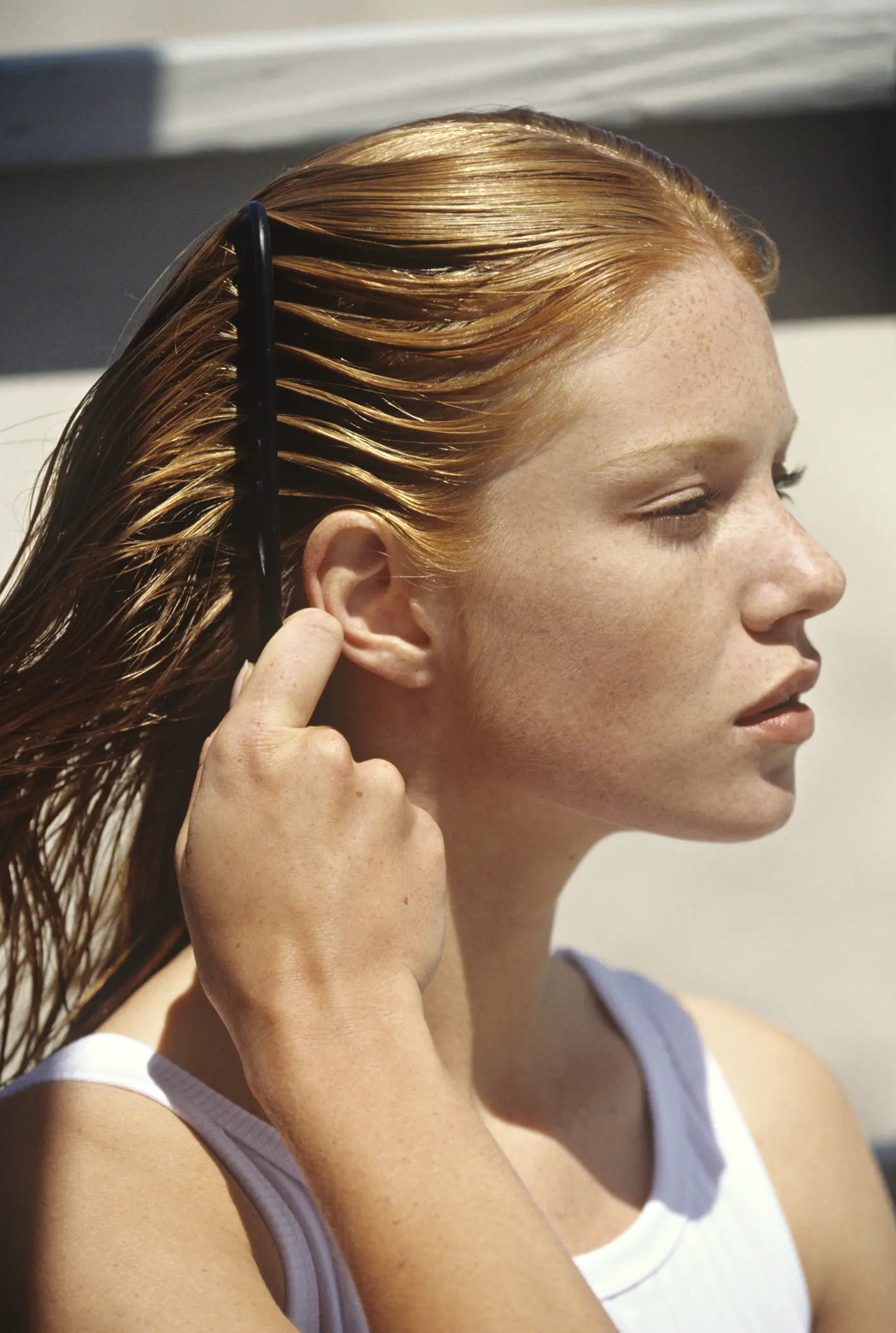 Junge Frau kämmt durch ihre nassen Haare