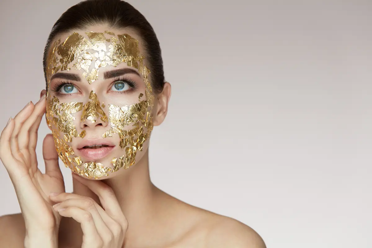 Frau mit Gesichtsmaske aus Blattgold