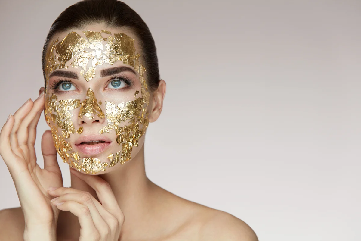 Frau mit Gesichtsmaske aus Blattgold