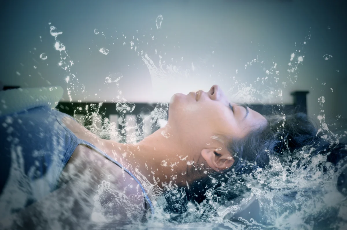 Frau liegt in spritzendem Wasser