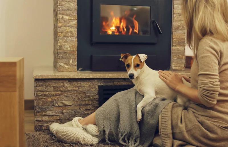 gemütliches-zuhause-frau-und-hund-entspannen-in-der-nähe-von-kamin
