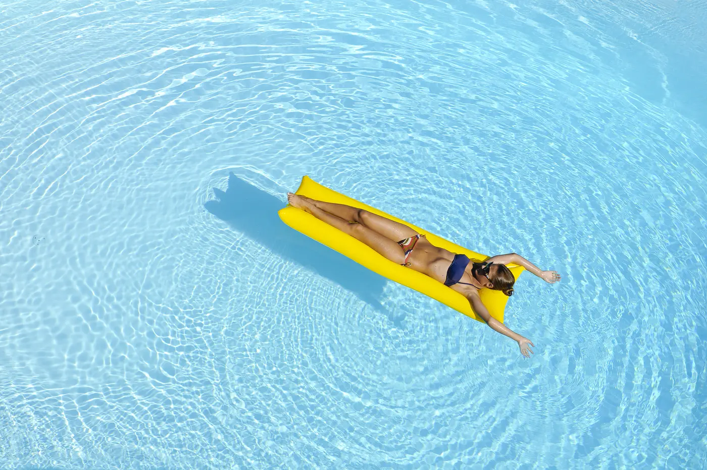Frau im Pool auf Luftmatratze