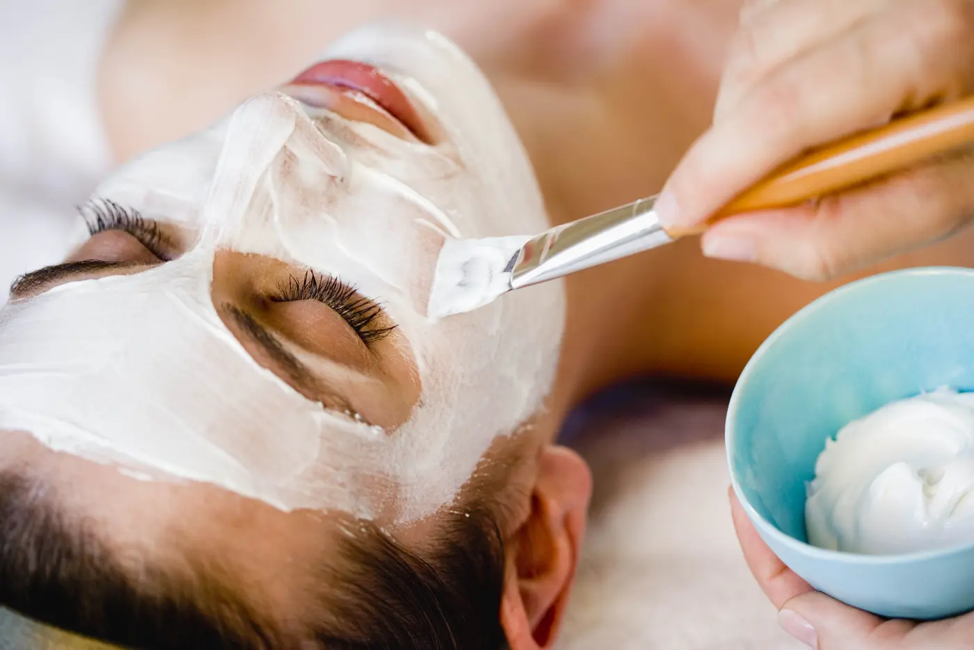 Junge Frau bekommt eine Gesichtsmaske in der Beauty Lounge