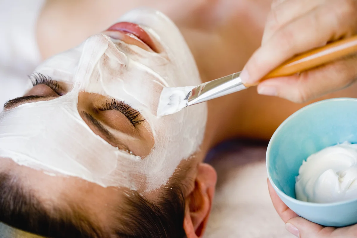 Junge Frau bekommt eine Gesichtsmaske in der Beauty Lounge