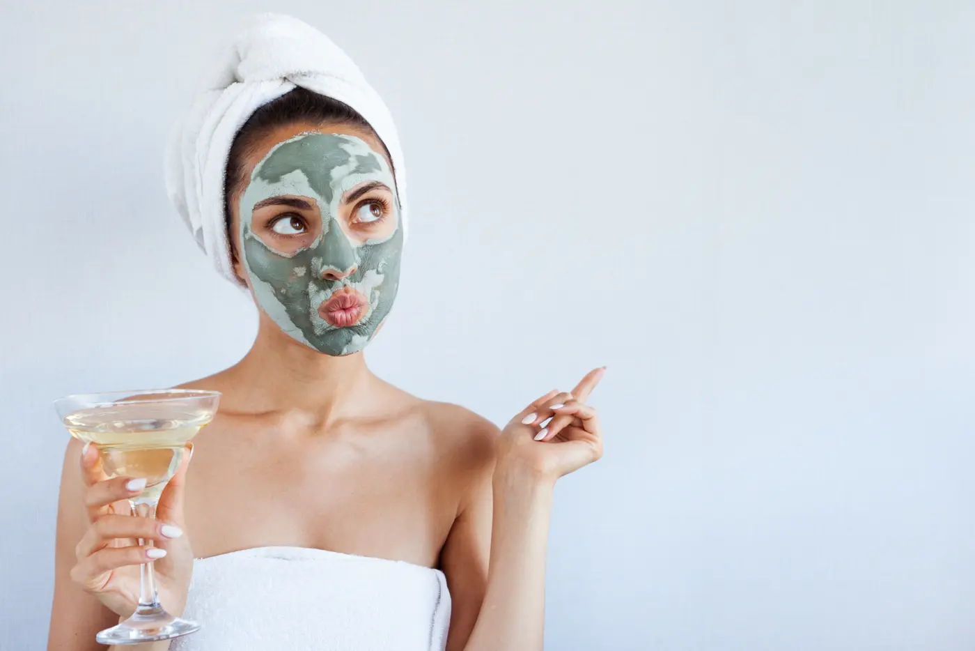 Frau mit Gesichtsmaske und Champagnerglas