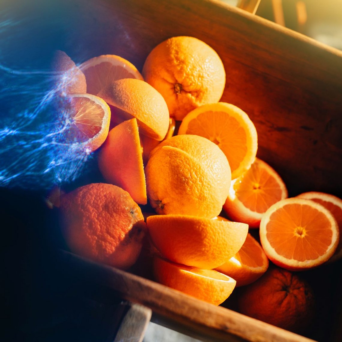 Detailaufnahme von mehreren Orangen und Orangenhälften