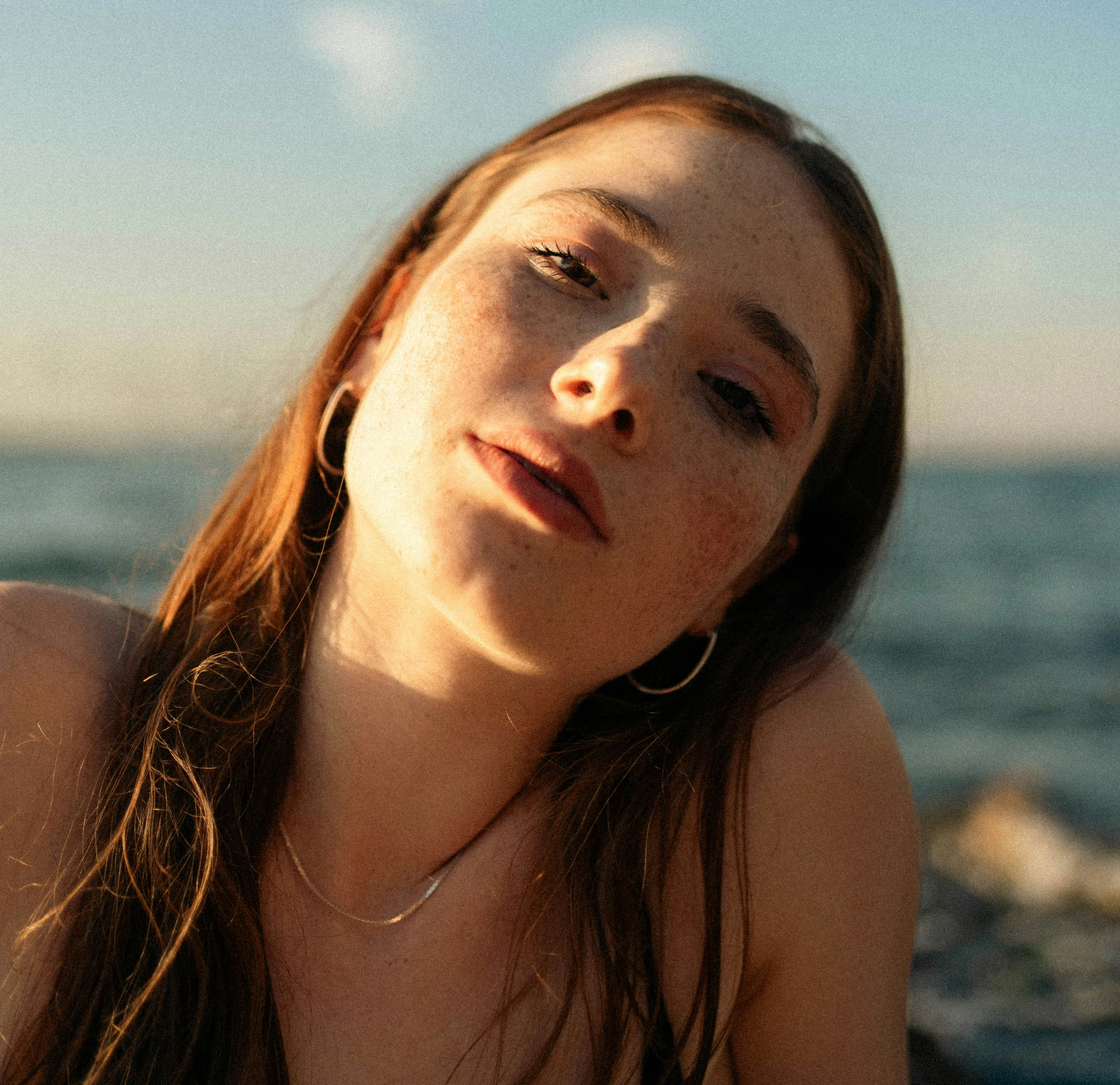 Junge Frau am Strand mit Sommersprossen
