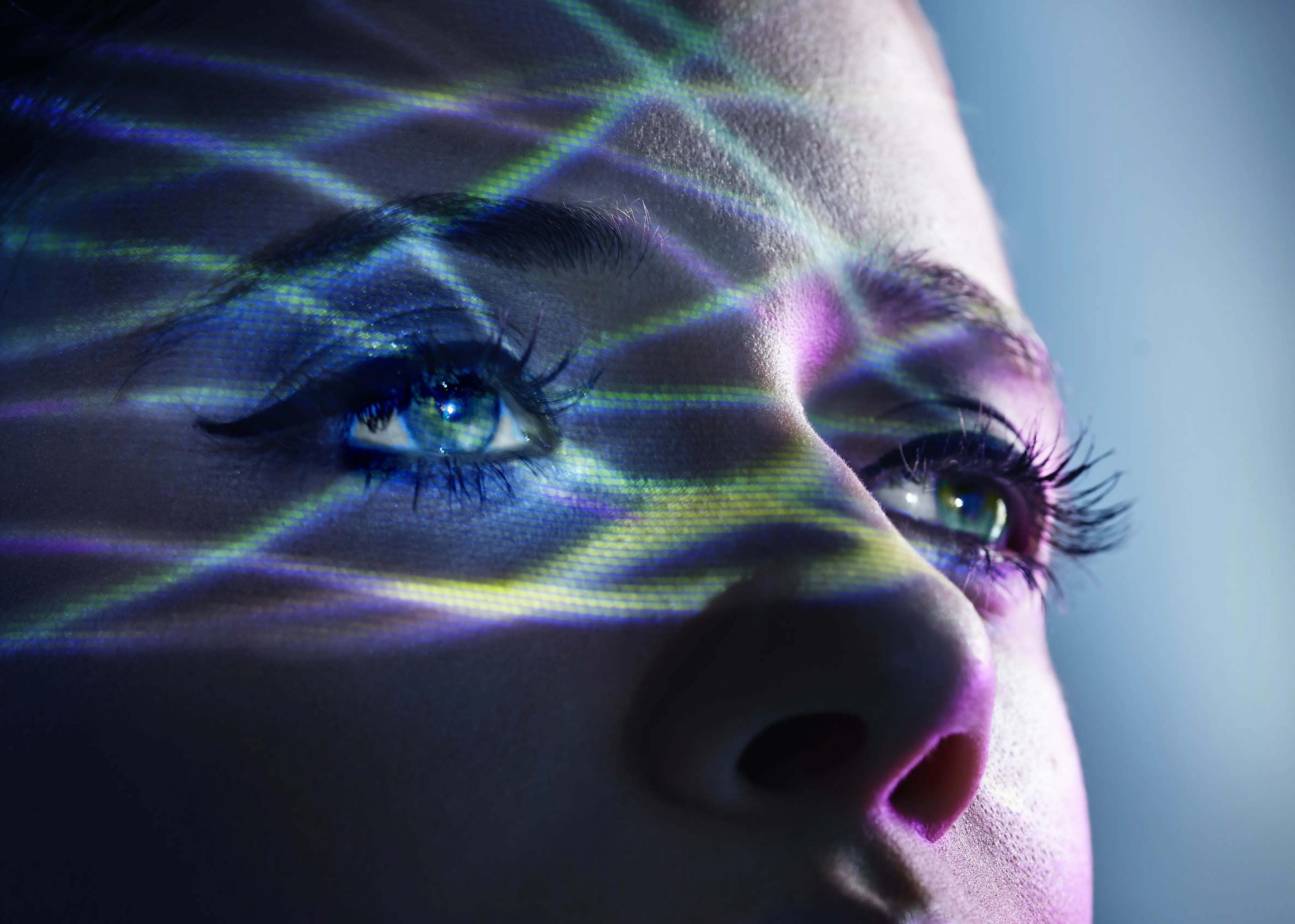 Blaue Lichtstrahlen auf dem Gesicht einer Frau