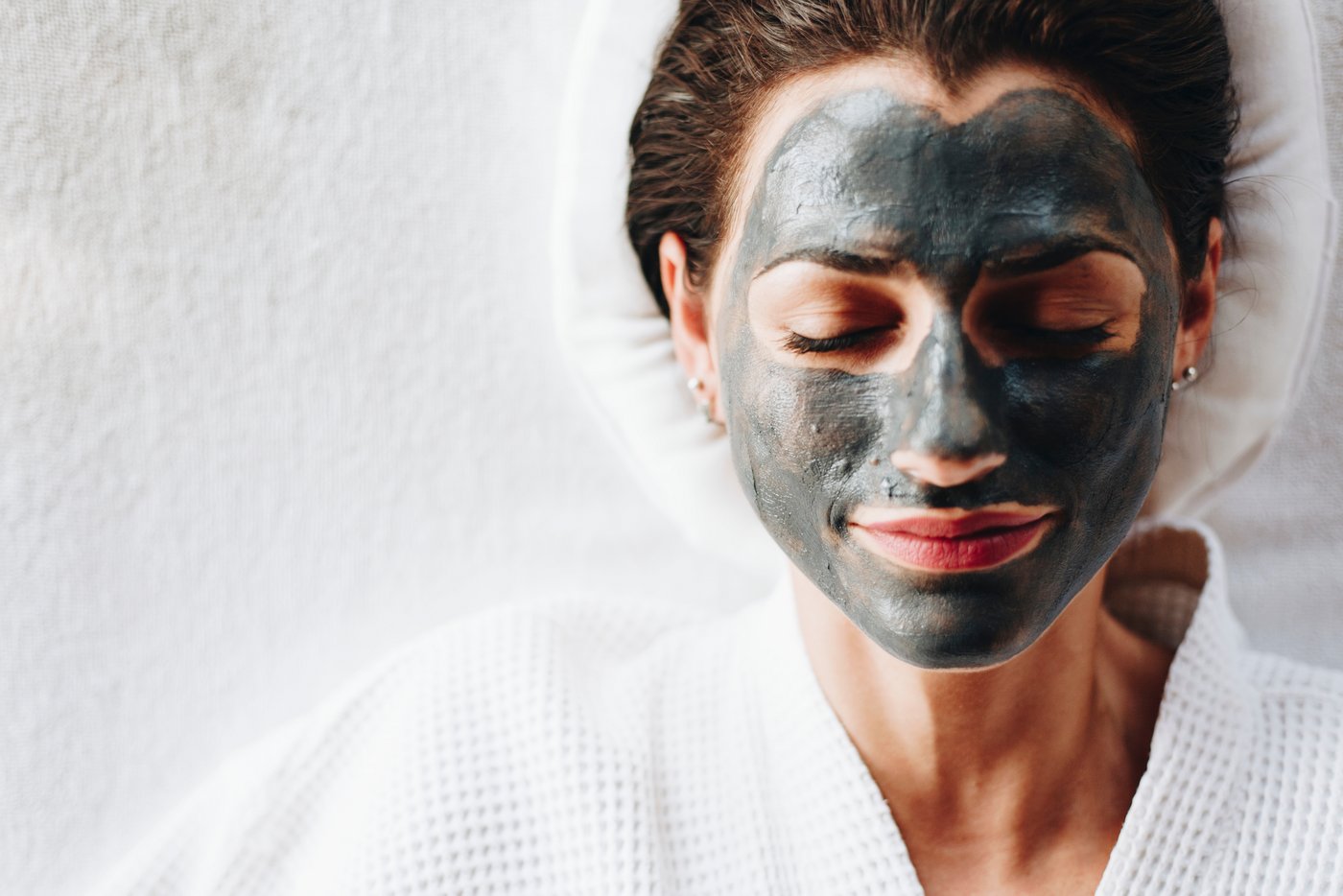 Frau liegt mit Gesichtsmaske im Bett