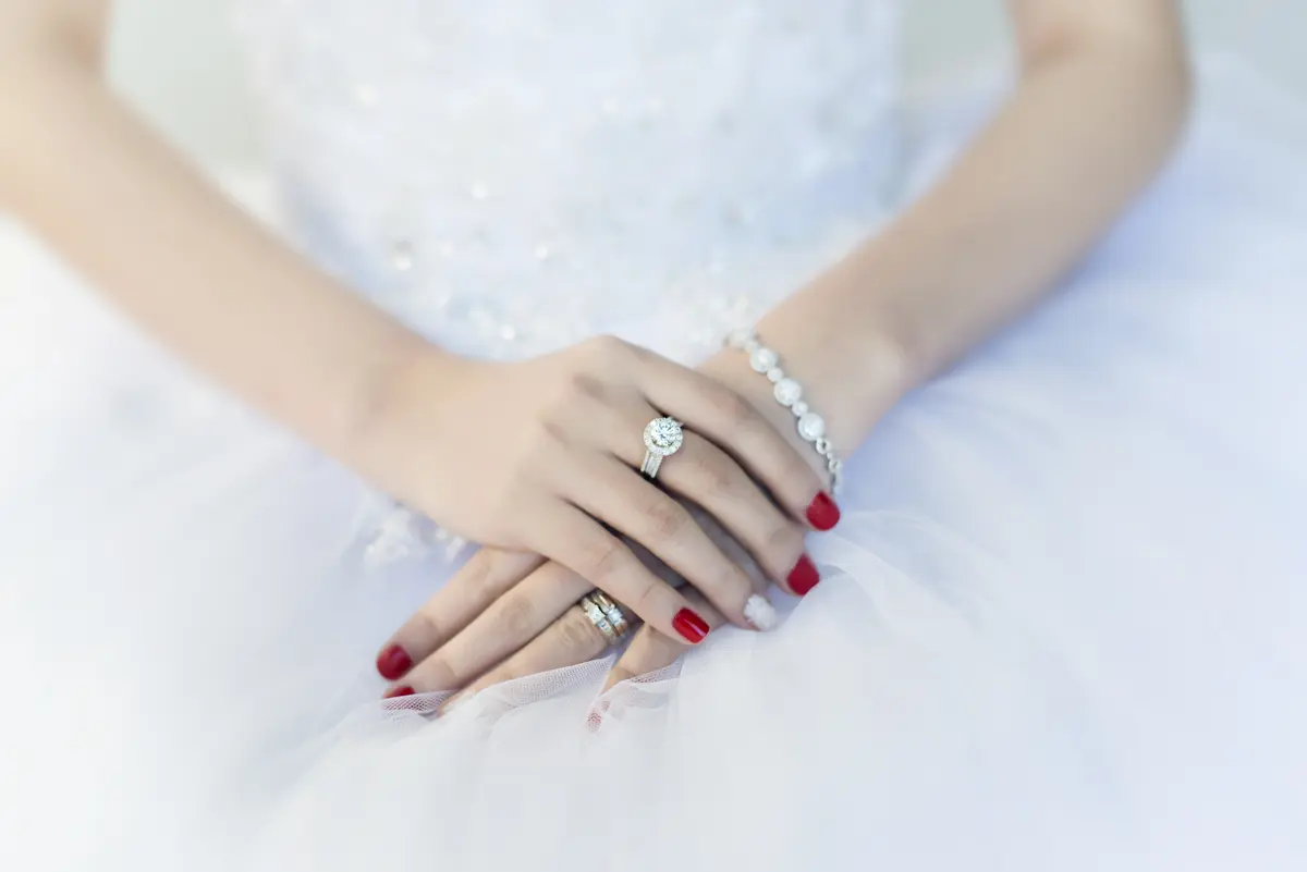 Hände einer Braut mit Ehering am Finger