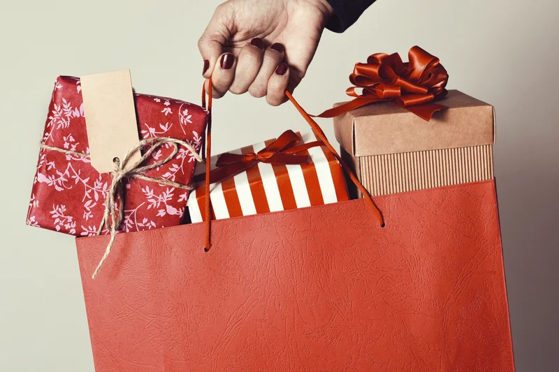 Frau hält Tüte mit Weihnachtsgeschenken
