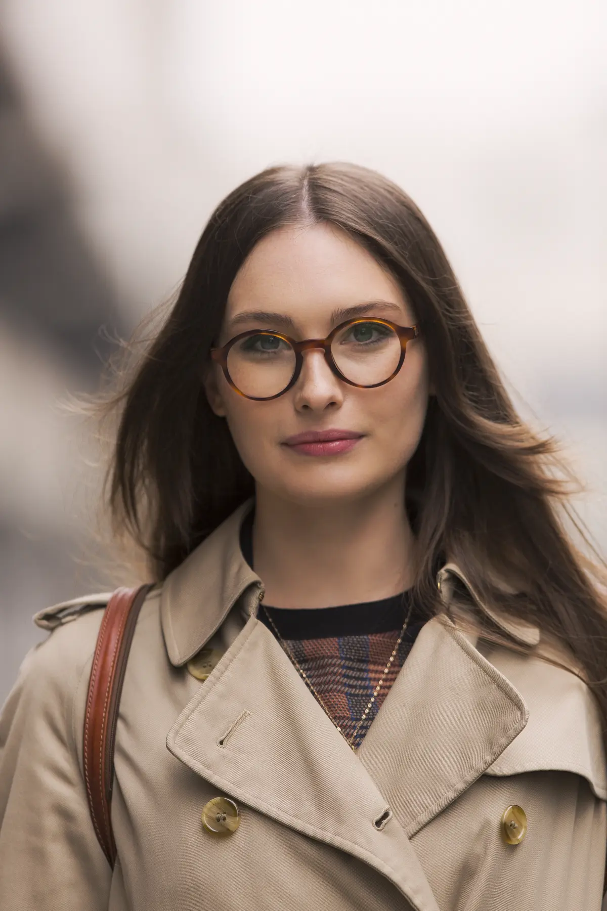 Junge, brünette Frau mit Brille lächelt in die Kamera