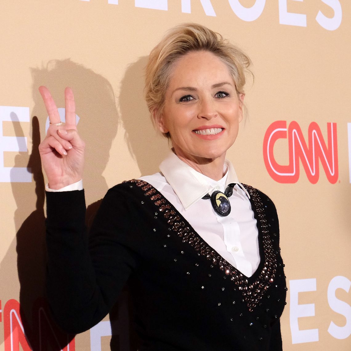 Sharon Stone zeigt ein Peace Zeichen auf dem Roten Teppich