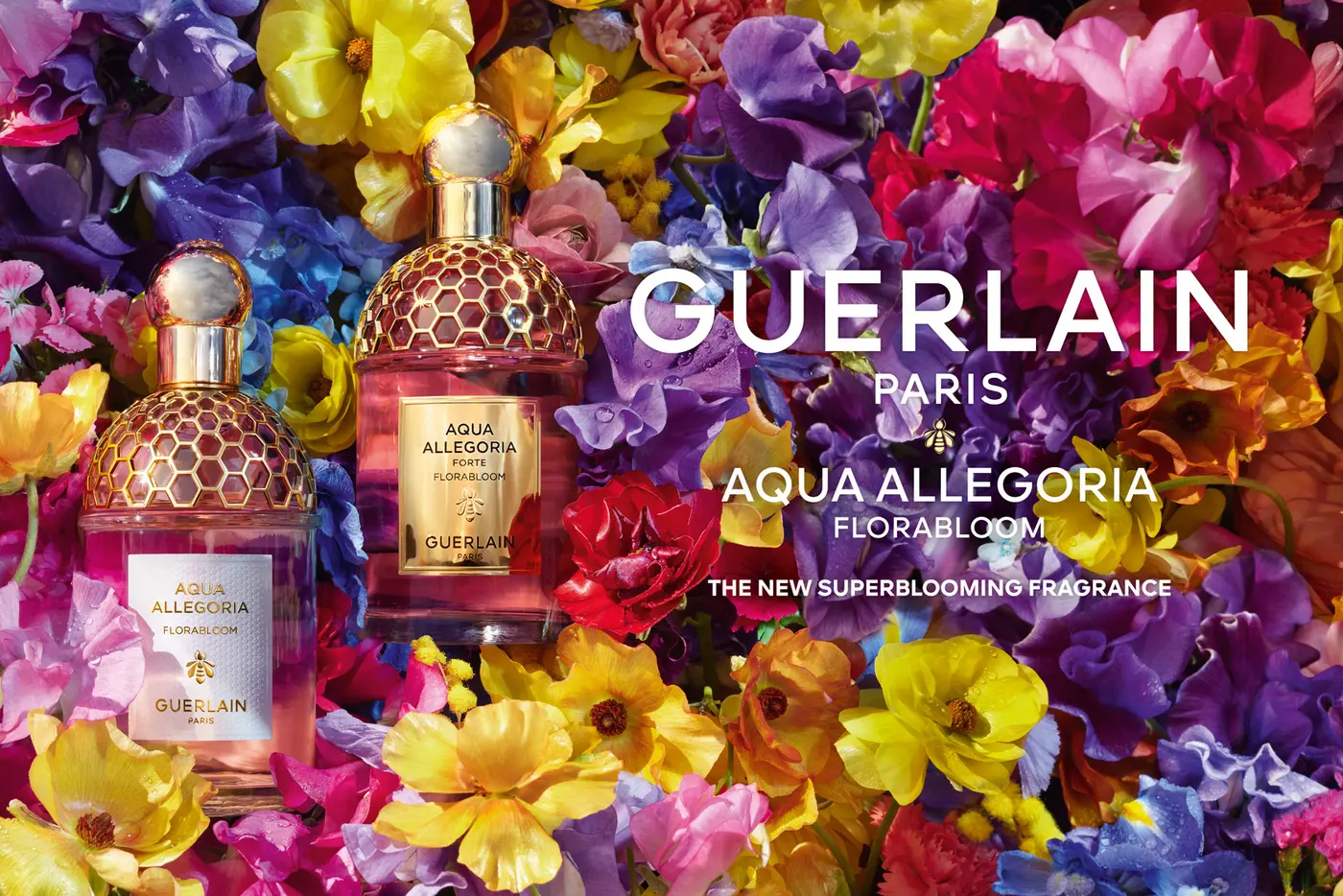 Blumenbouquet aus bunten Blüten, darauf ein GUERLAIN Flakon