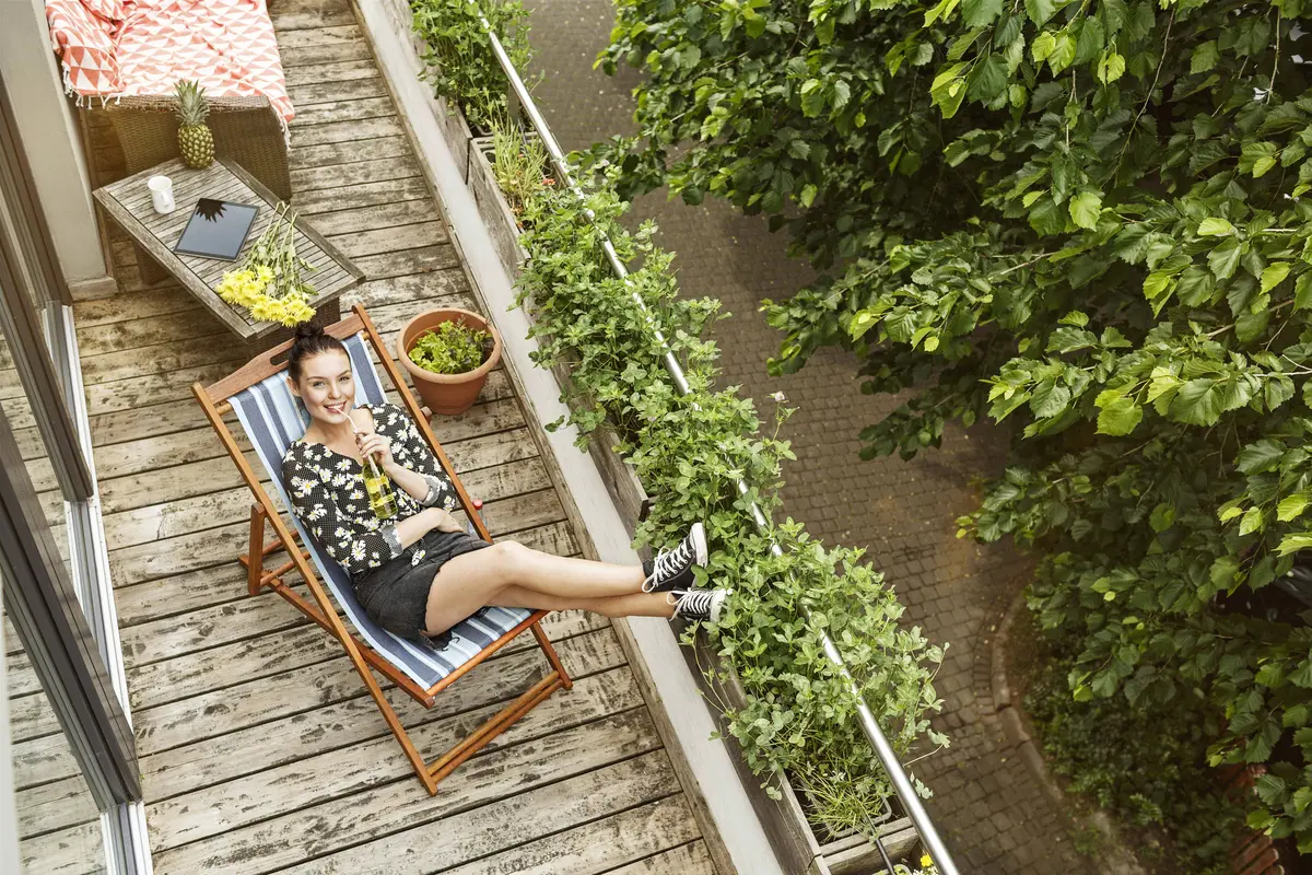 Frau urlaubt auf dem Balkon