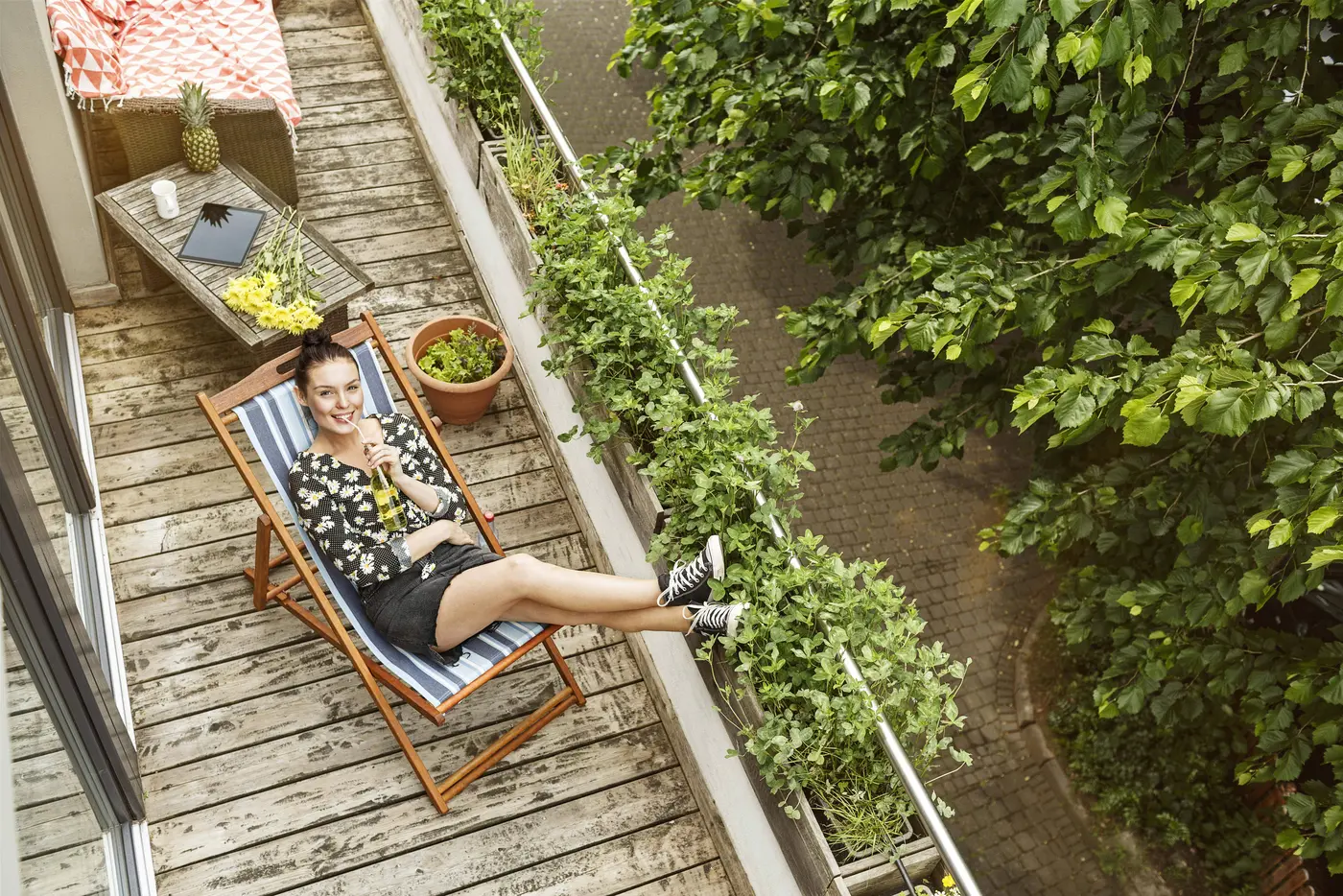 Frau urlaubt auf dem Balkon