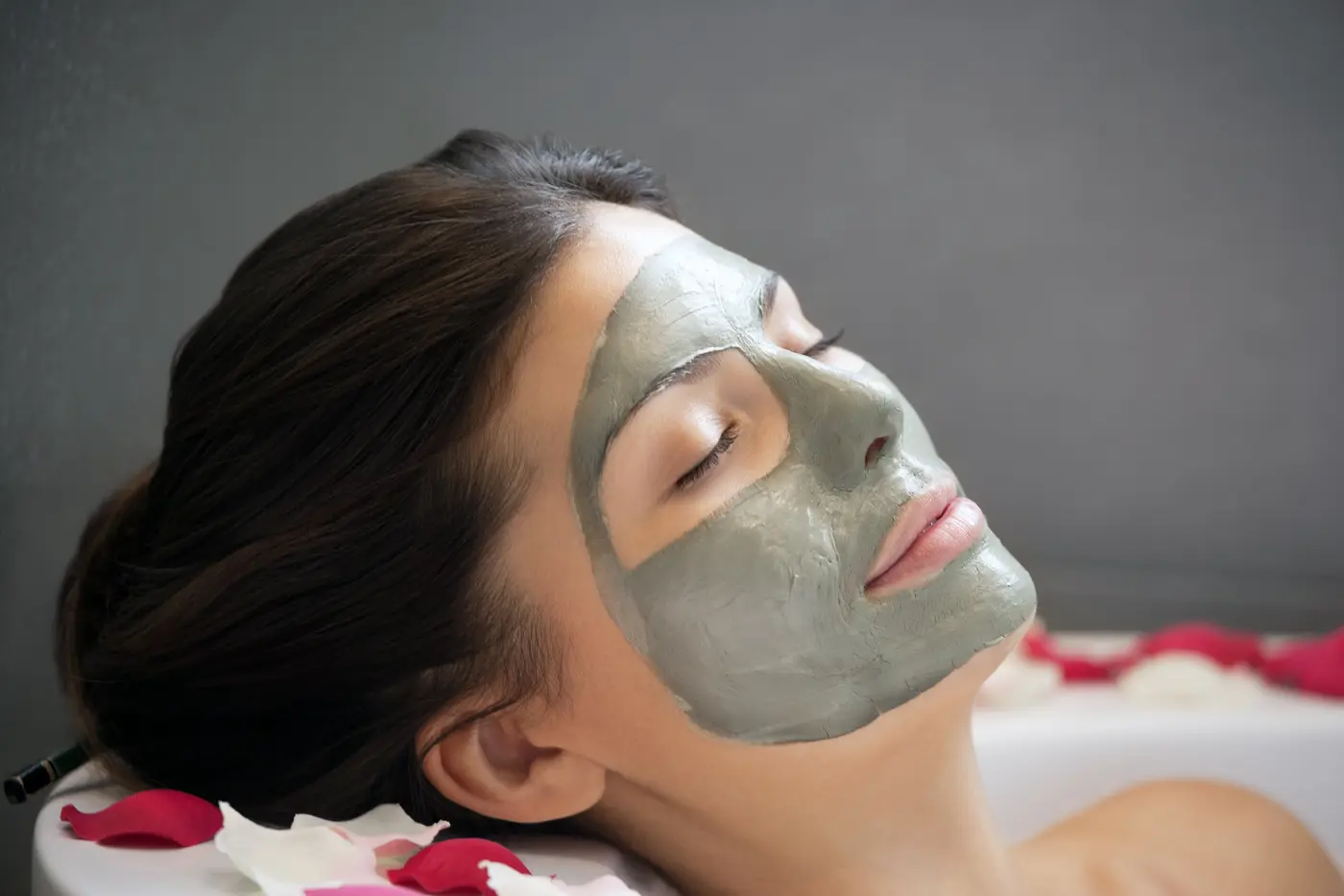 Frau mit Gesichtsmaske in Badewanne