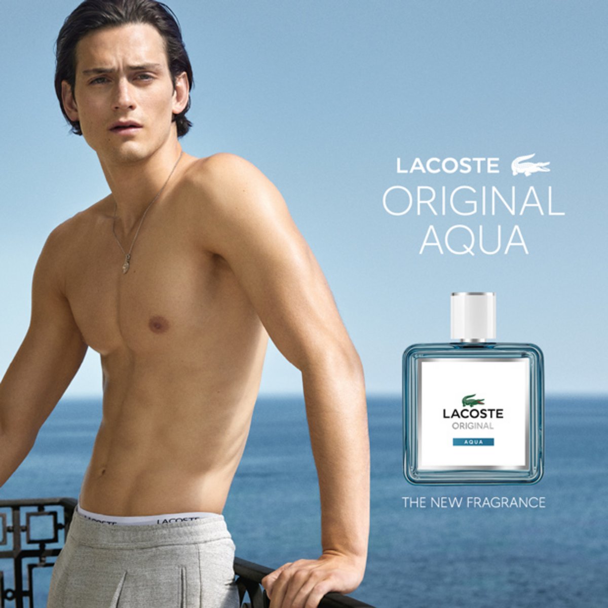 Männliches Model am Meer neben Lacoste Original Aqua Eau de Toilette Flakon, frischer aquatischer Herrenduft mit maritimer Ausstrahlung