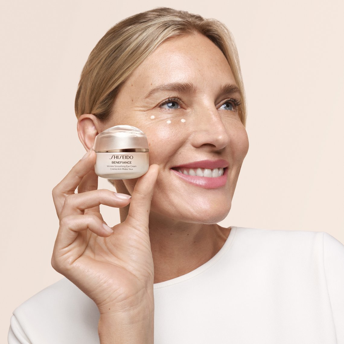 Frau hält Tiegel der Wrinkle Smoothing Eye Cream von Shiseido in der Hand