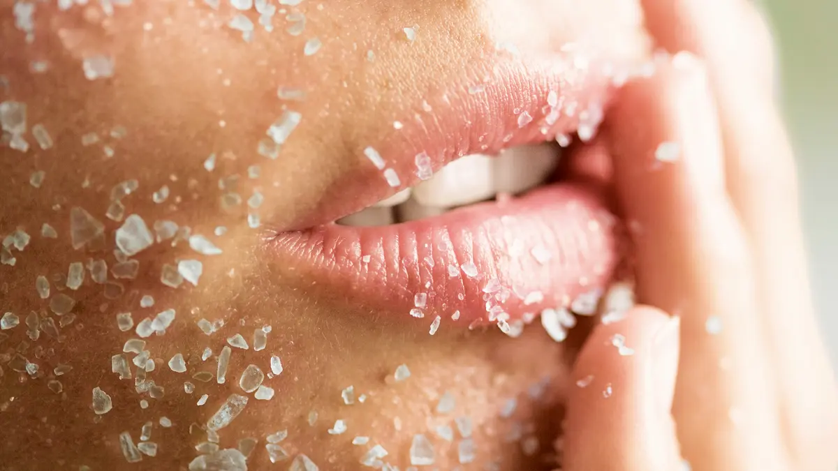 Eine Frau mit Peeling-Kristallen im Gesicht