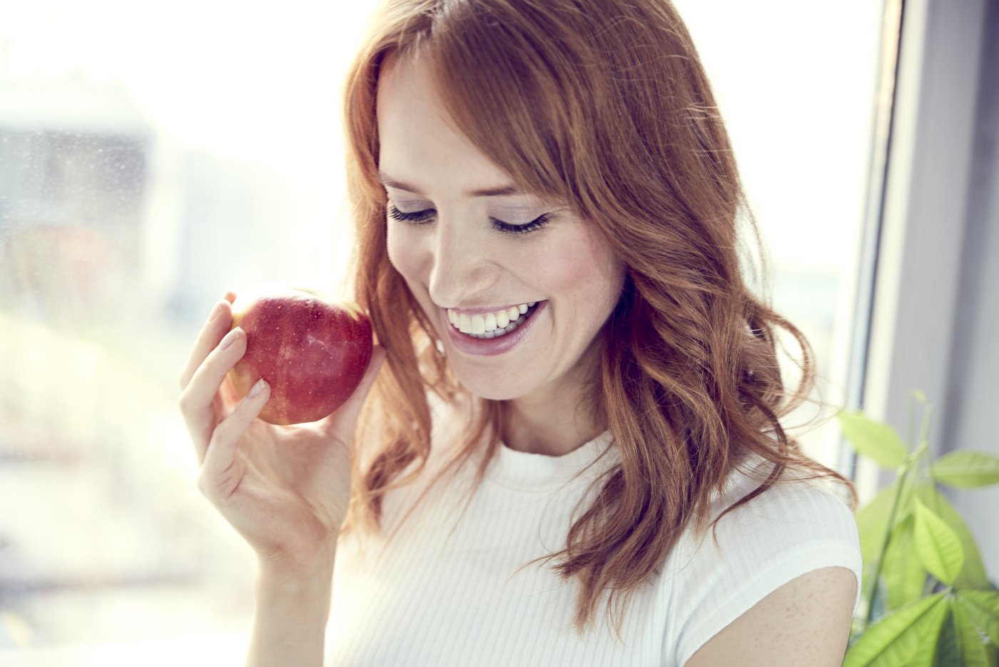 Rothaarige Frau mit Apfel