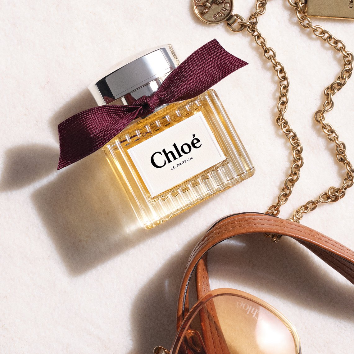 Moodbild Chloé Le Parfum, Flakon mit Accessoires auf weißem Hintergrund