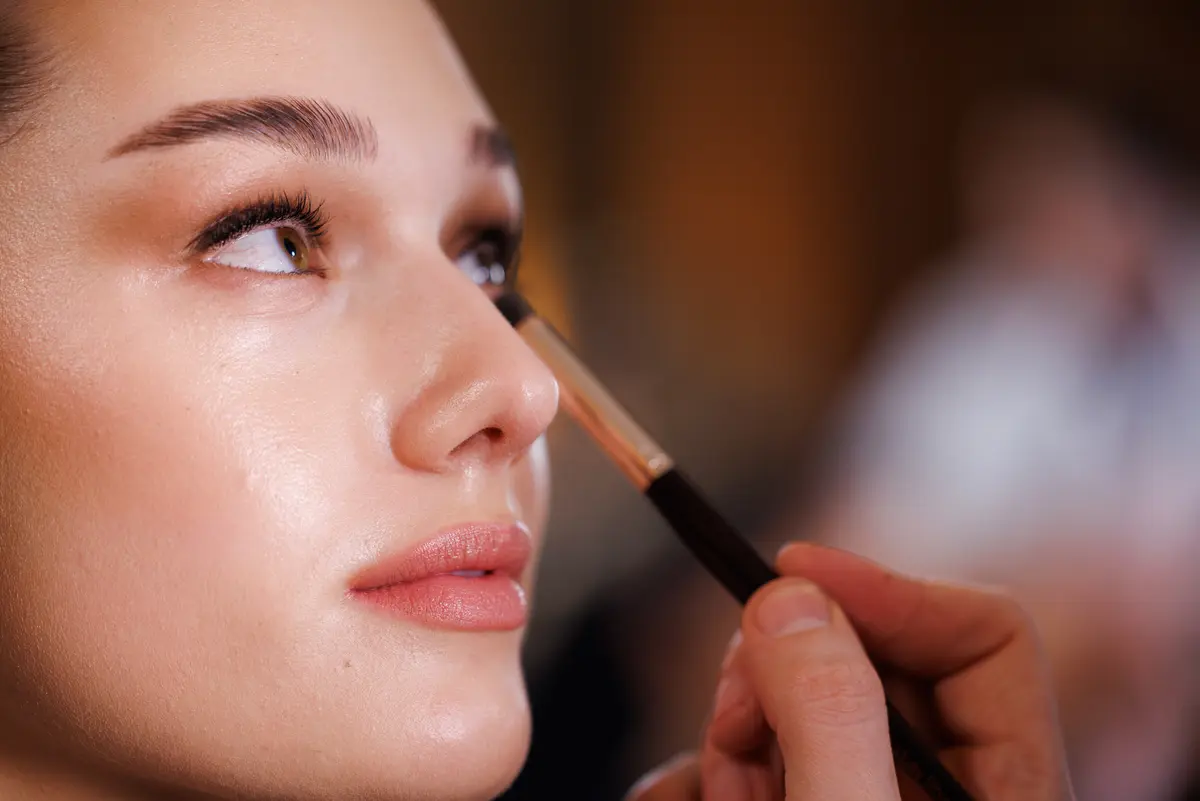 Ein Model wird Backstage geschminkt bei derParis Fashion Week - Haute Couture Spring Summer 2023