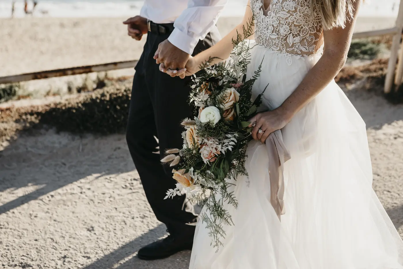 Hochzeitspaar läuft Hand in Hand