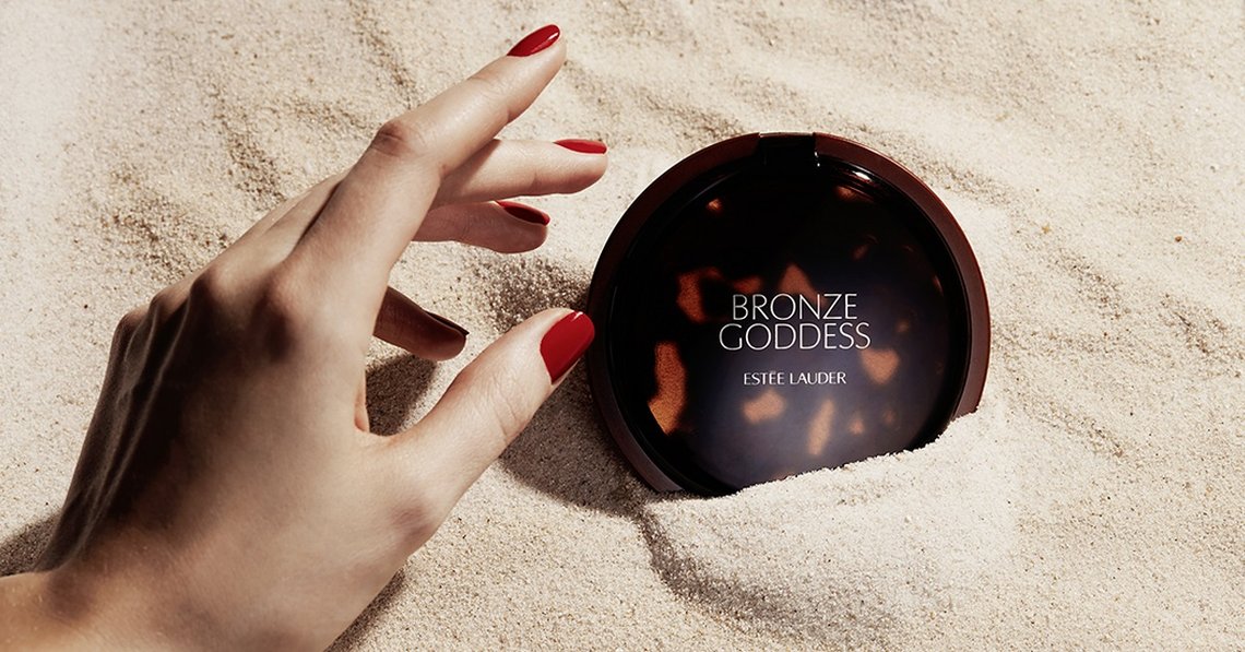 Frauenhand mit Estée Lauder Bronze Goddess Bronzing Powder