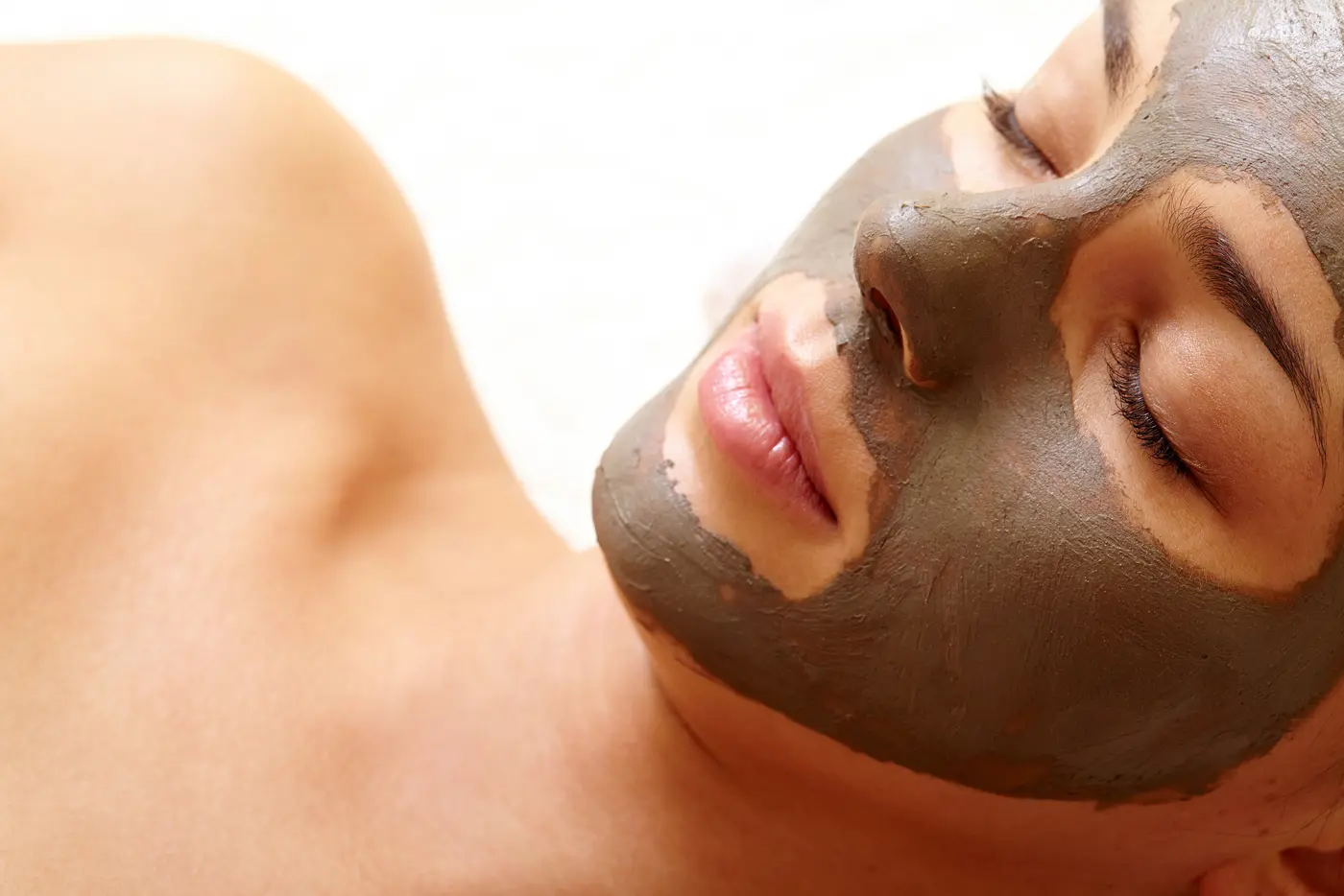 Frau mit geschlossenen Augen und Tonerde Maske