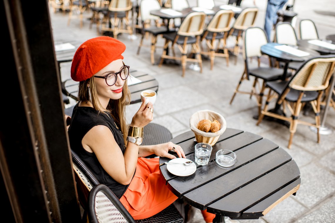 Frau in Cafe in Paris mit Kaffee und Croissant Frau in Cafe in Paris mit Kaffee und Croissant