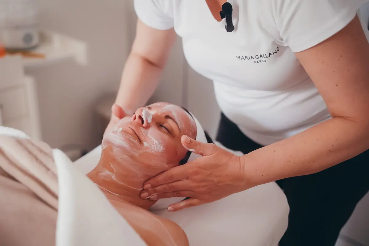 Kosmetikerin gibt der Kundin eine Gesichtsmassage