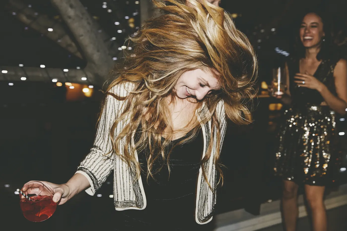 Zwei fröhliche, junge Frauen in Silvester-Looks