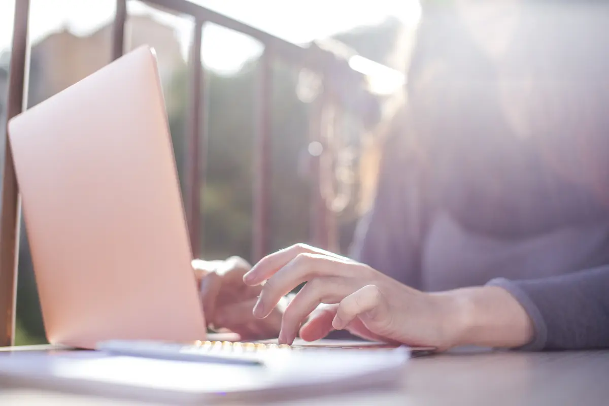 Hände in der Sonne am Laptop