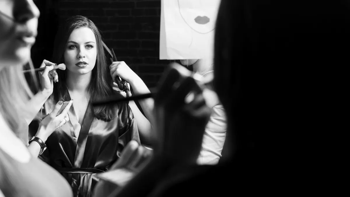 Frau vor dem Spiegel beim Schminken