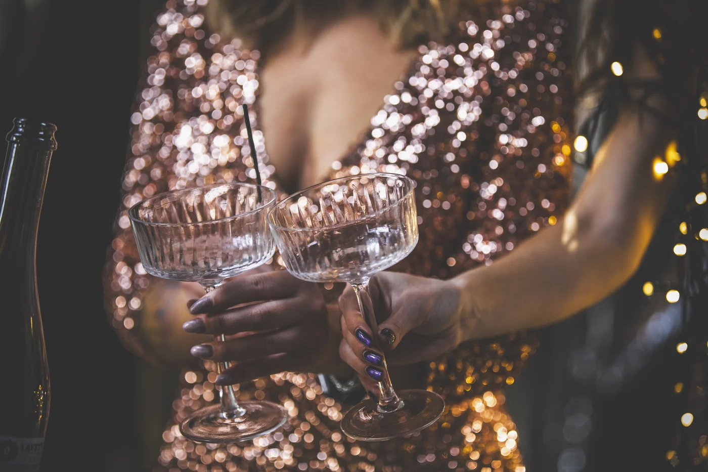 Close-up glitzerndes Paillettenkleid und zwei Champagnergläser 