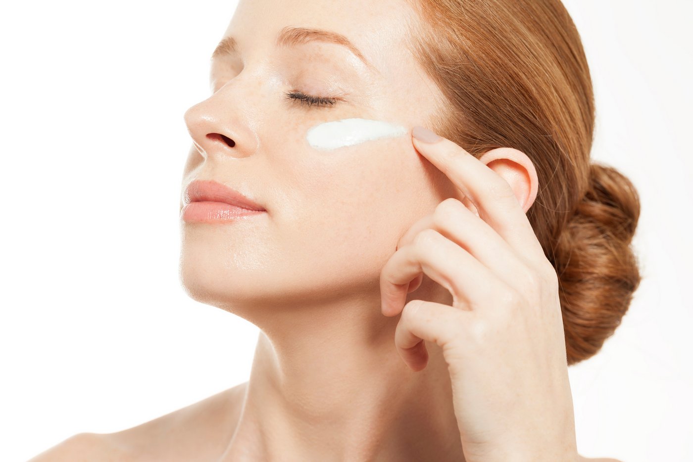 Frau trägt Lotion auf ihr Gesicht auf