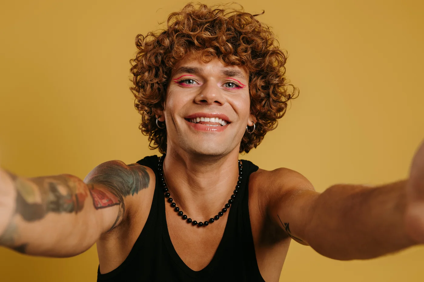 Mann mit Make-up und Tattoos