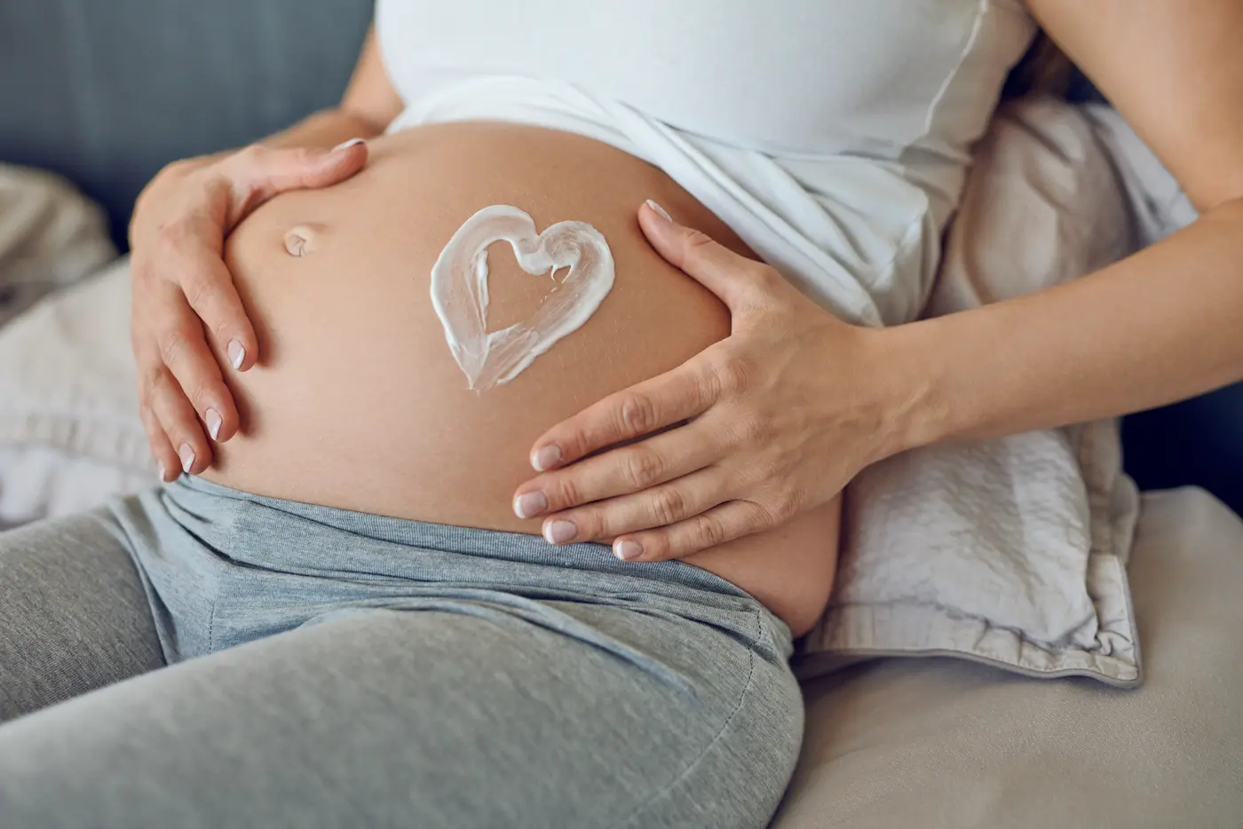 Creme auf dem Bauch einer schwangeren Frau