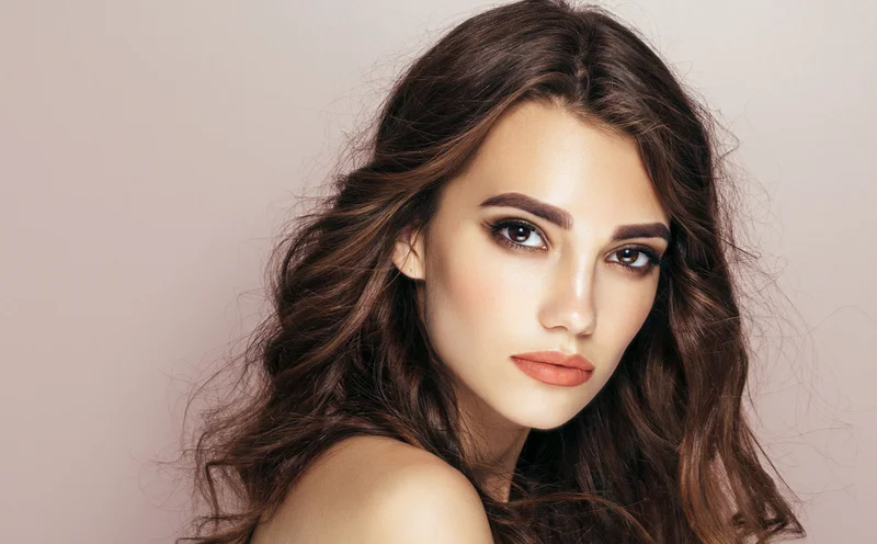 Frau mit dunklen Haaren, rose Hintergrund, natürlicher Look