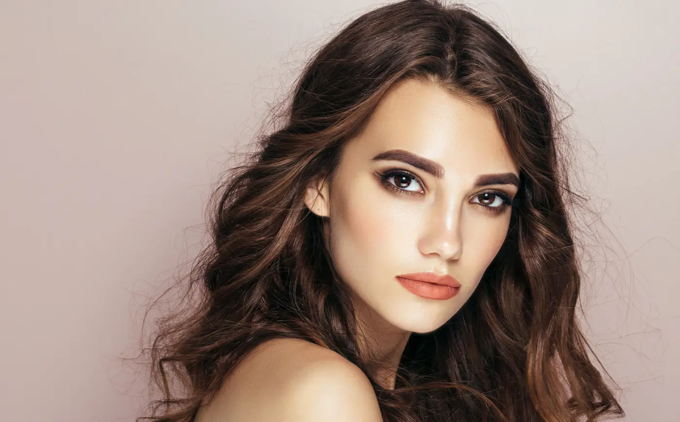 Frau mit dunklen Haaren, rose Hintergrund, natürlicher Look