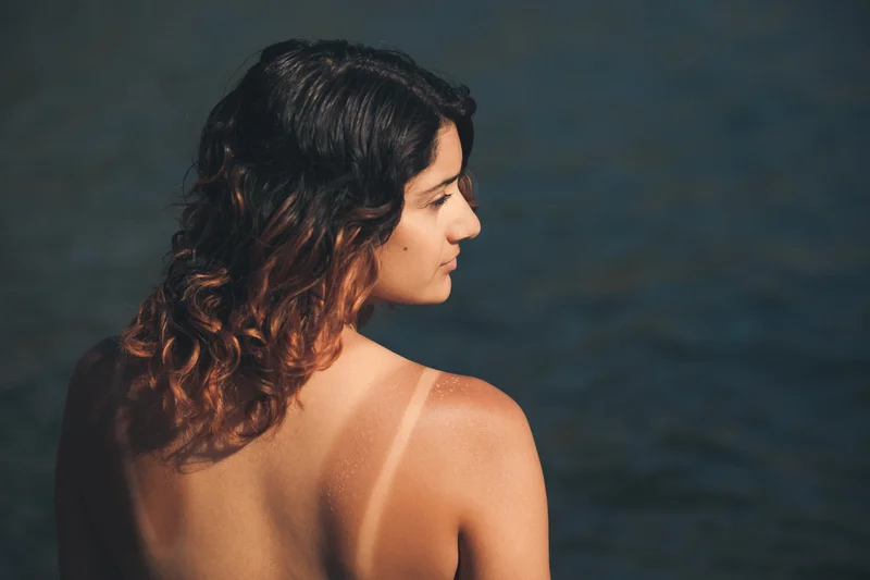 Frau mit Tanlines am Strand