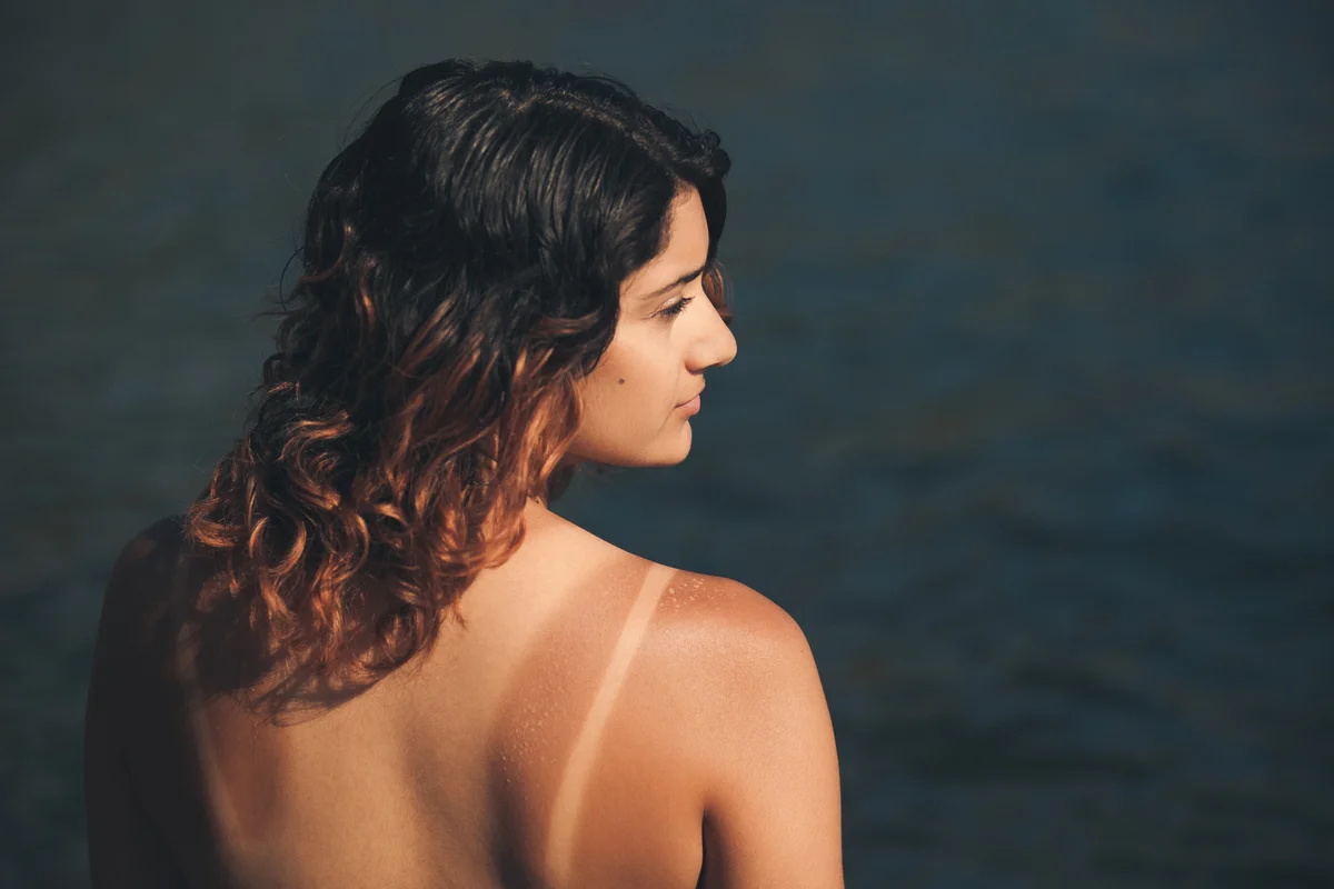 Frau mit Tanlines am Strand