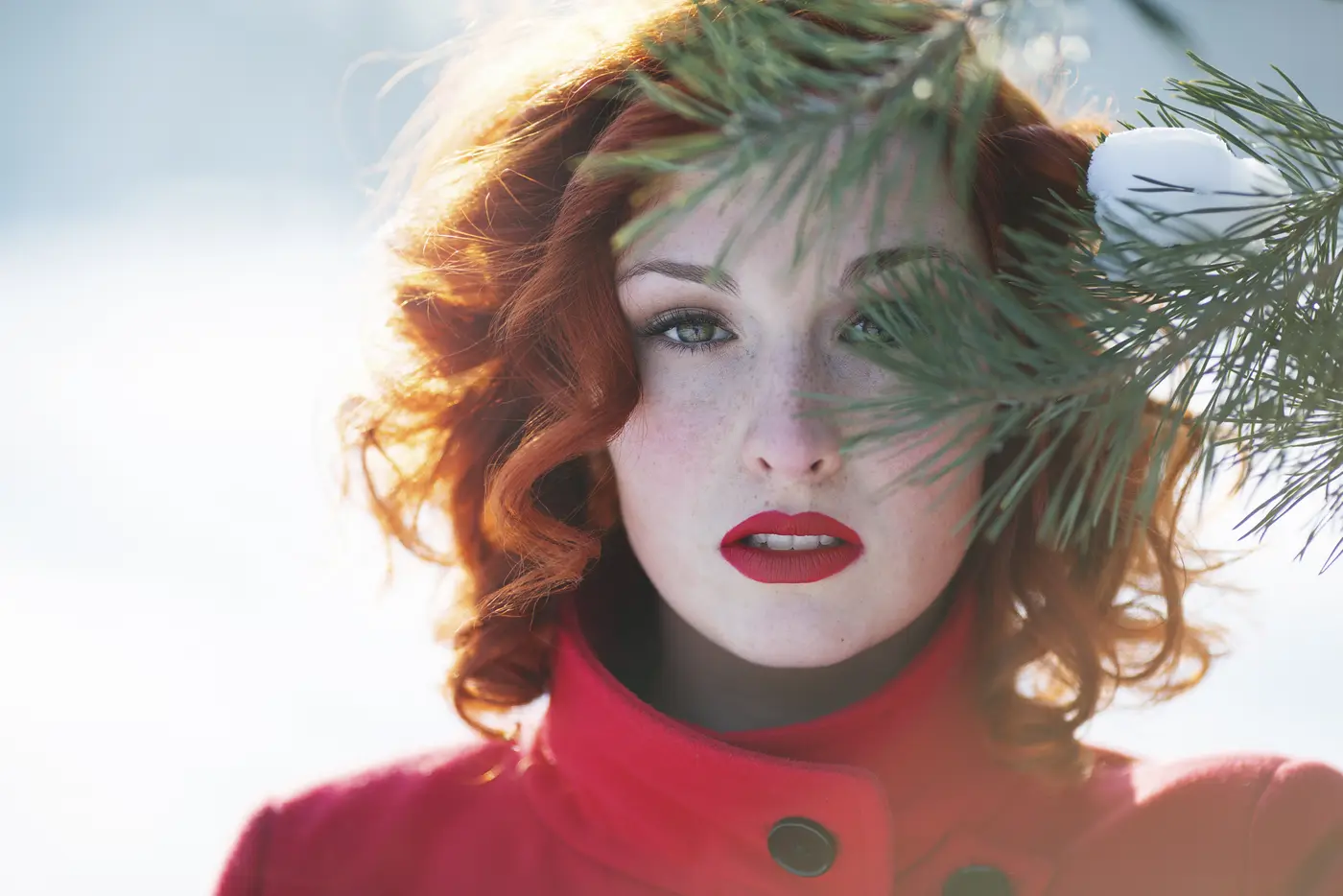 Junge Frau mit roten Lippen in Winterlandschaft