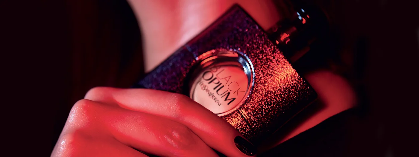 Eine Frau hält den Flakon von Yves Saint Laurent Black Opium in ihrer Hand