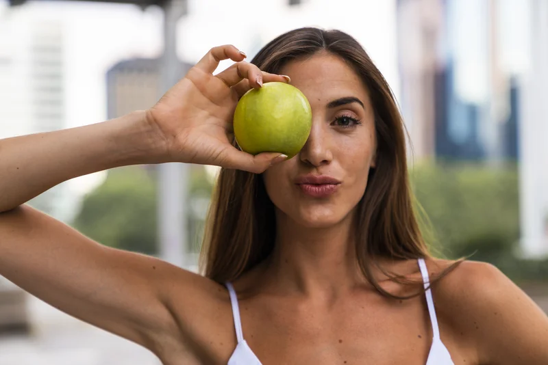 Ernährung für schöne Haut: Frau mit Apfel