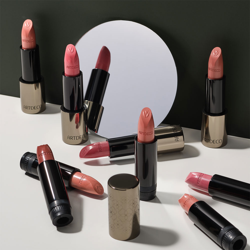 Farbpalette der Green Couture Kollektion, verschiedene Lippenstifte vor einem kleinen Spiegel arrangiert