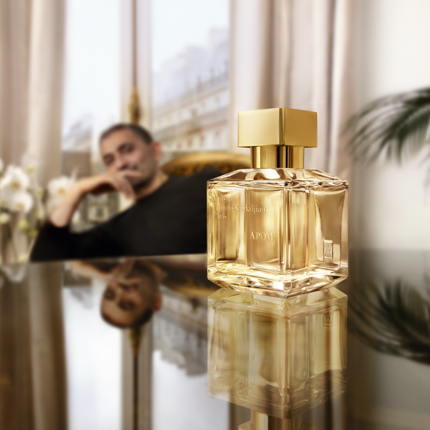 Fokus auf den Flakon von APOM (Maison Francis Kurkdjian), im Hintergrund der Parfümeur Francis Kurkdjian