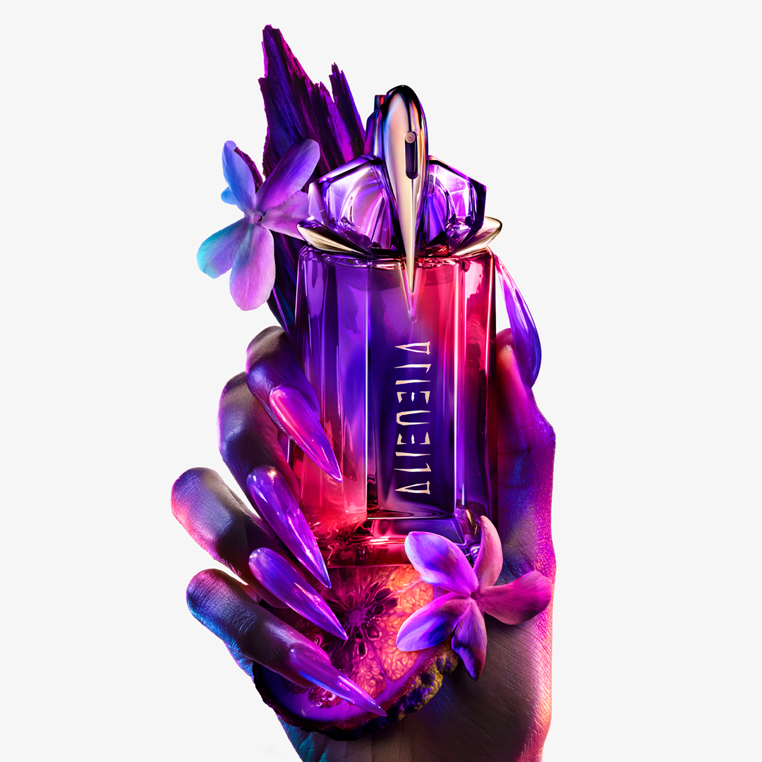 Eine Hand hält den Flakon ALIEN HYPERSENSE, mit Ingredienzen arrangiert, Bild ist lila eingefärbt